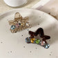 Beau star shaped claw clip open, displaying inner claw grips