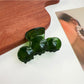 Beau hair claw clip with wavy design placed next to a mirror