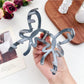 Side view of Beau ombre heart shaped bow claw clip highlighting clip mechanism