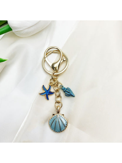Keypus pendant keychain resting on a blue fabric, emphasizing its color contrast