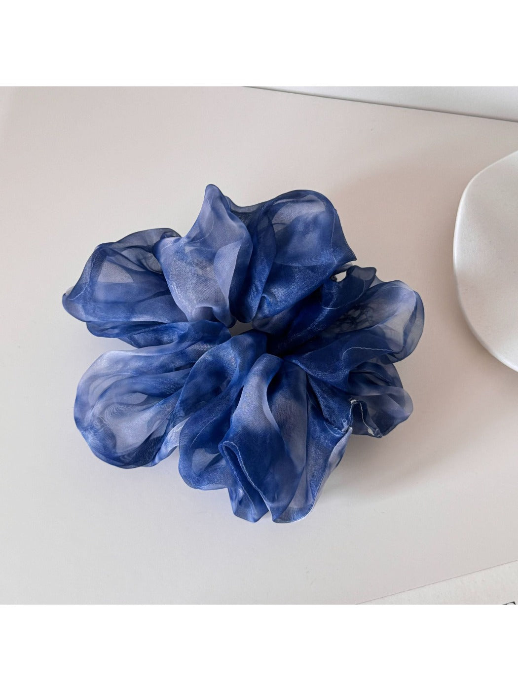 Top view of multi color tulle scrunchie highlighting gathered fabric design