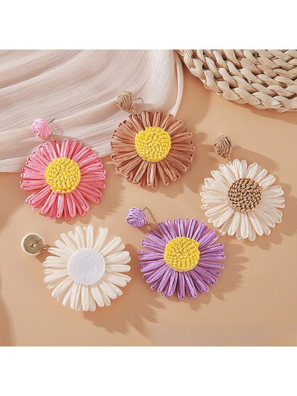 Pair of vintage raffia sunflower earrings displayed on a white background