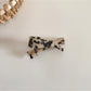 Beau irregular bow hair clip placed next to matching accessories