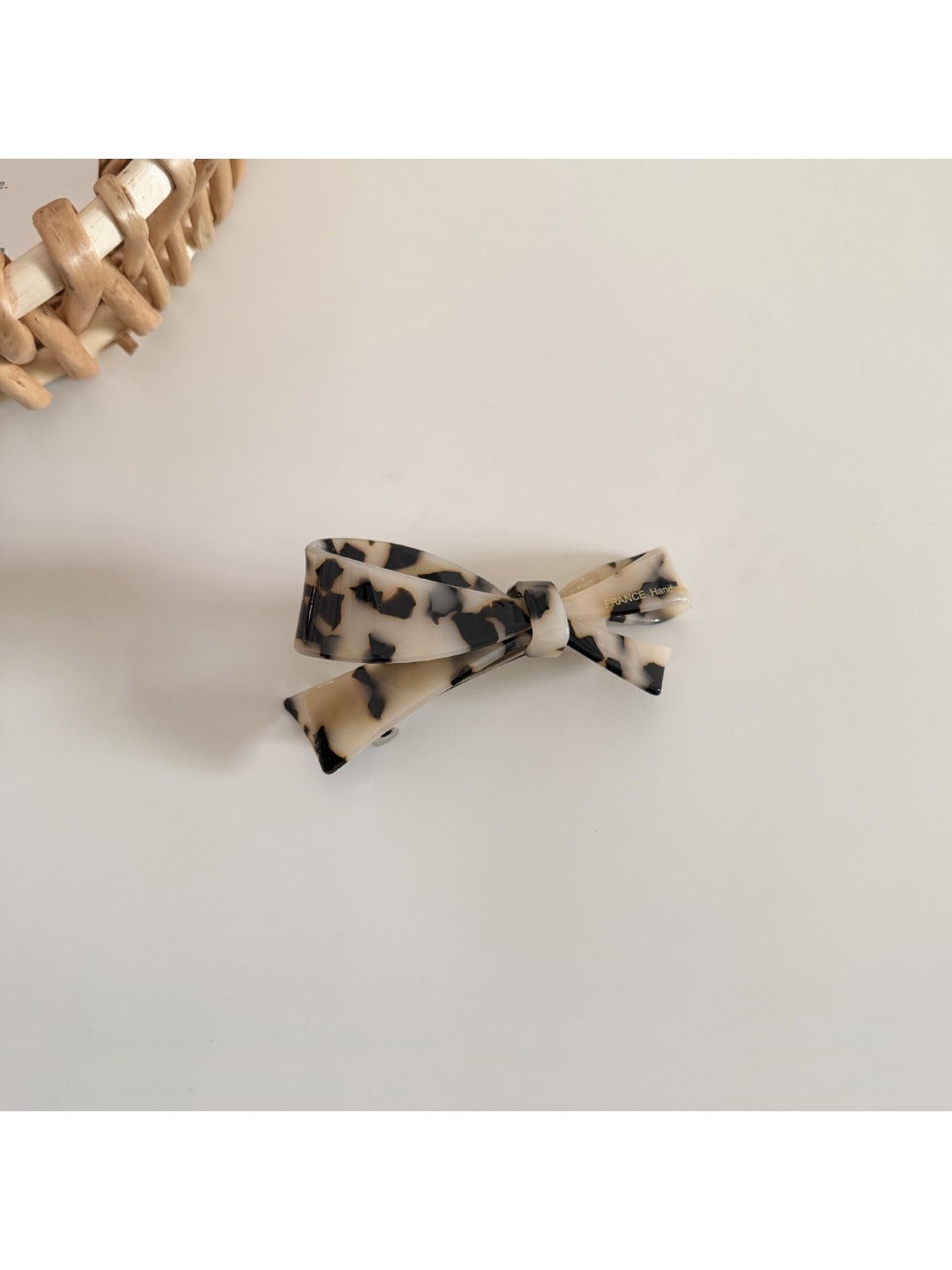 Beau irregular bow hair clip placed next to matching accessories