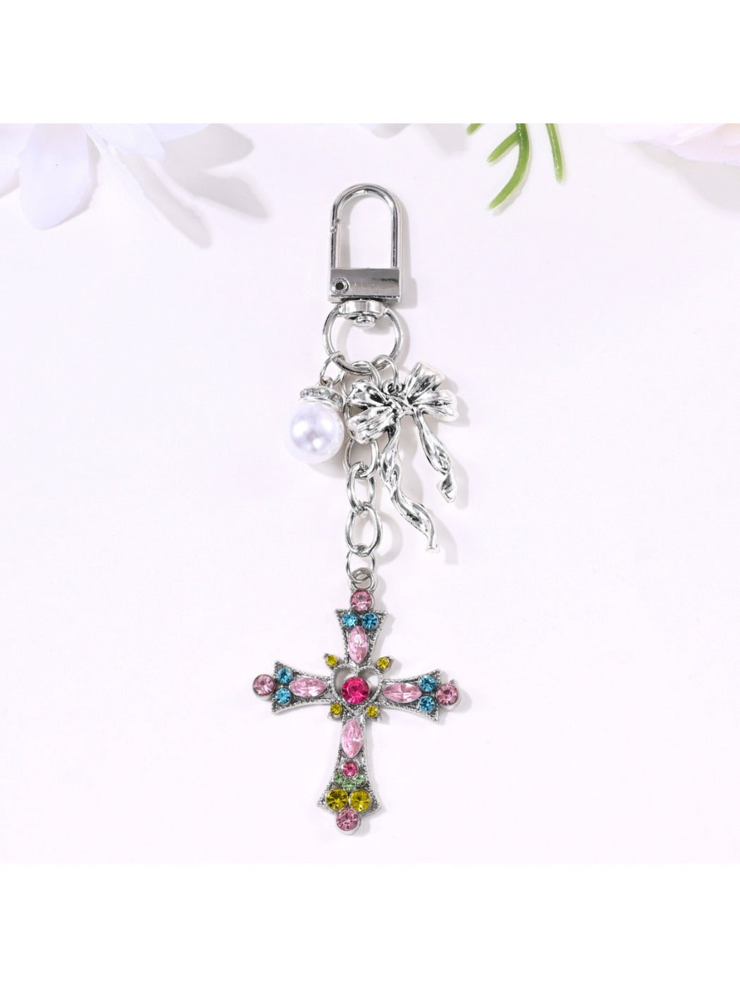 Alloy heart bow keychain hanging from a bag zipper pull