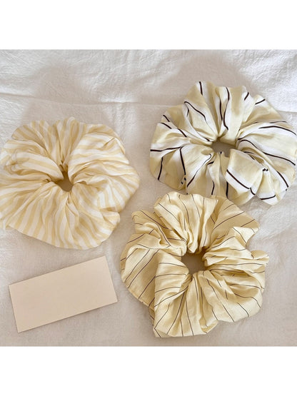 Yellow scrunchie with white and orange stripe print on a white background