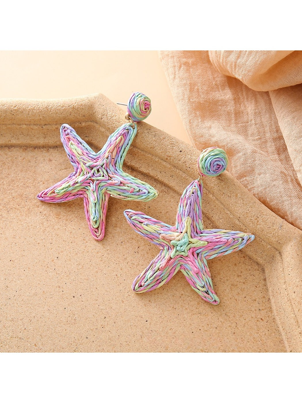 Starfish shaped drop earrings hanging from a jewelry stand
