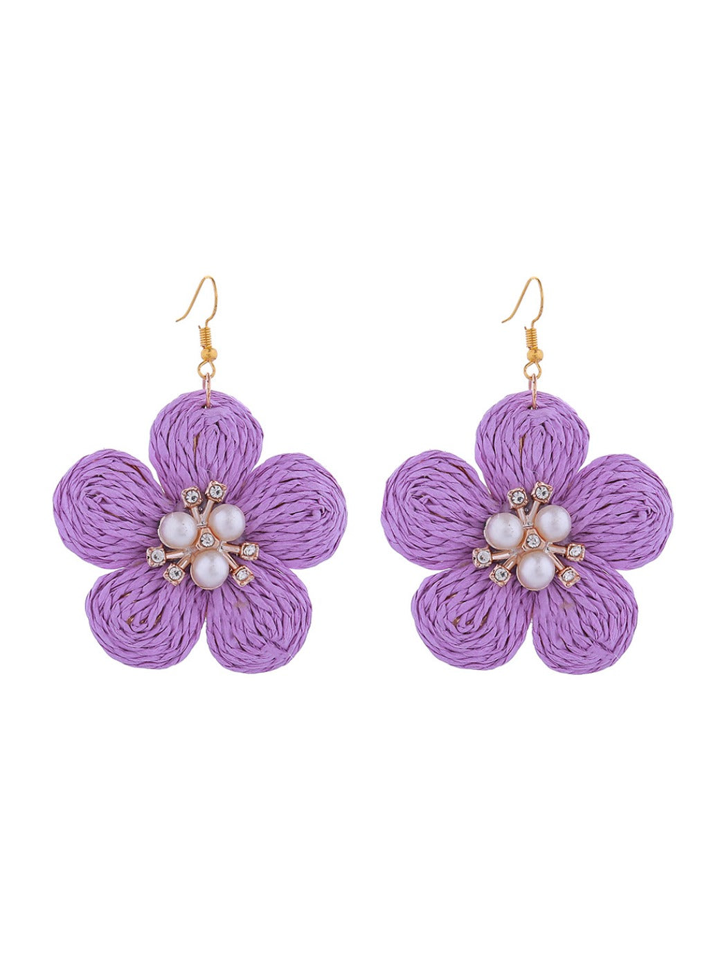 Earedge raffia flower earrings hanging on a jewelry stand with soft lighting