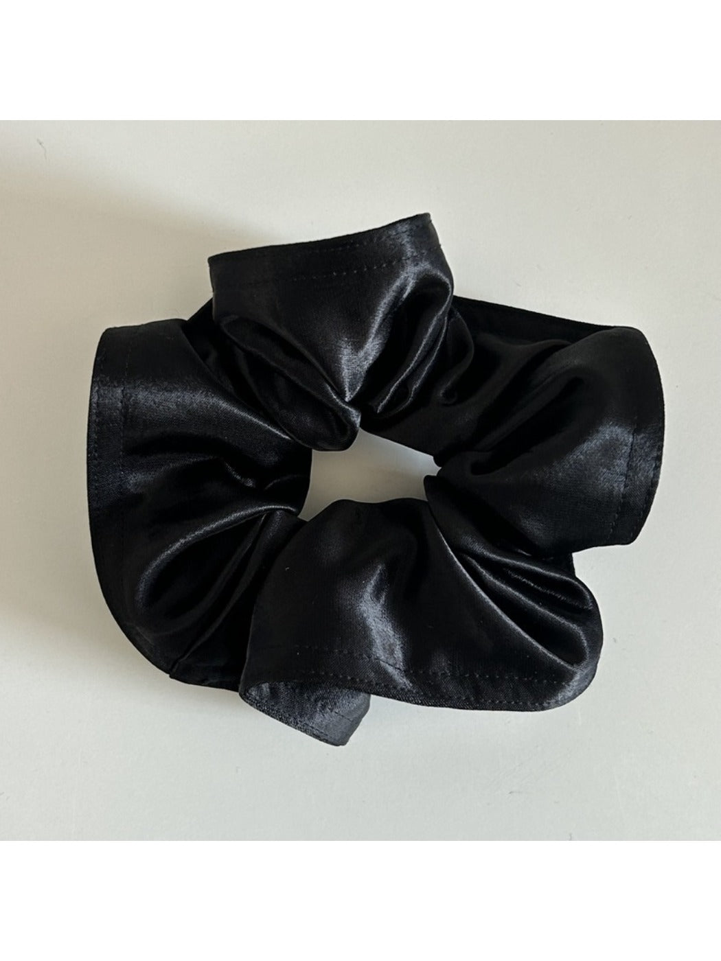 Model wearing Gifty satin scrunchie styled in a low bun with matching outfit