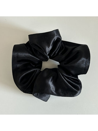 Model wearing Gifty satin scrunchie styled in a low bun with matching outfit