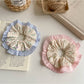 Close-up of Gifty ruffle scrunchie with tiny floral print on fabric