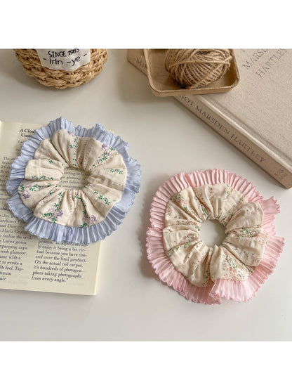 Close-up of Gifty ruffle scrunchie with tiny floral print on fabric