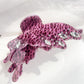 Beau leopard print butterfly claw clip next to matching accessories