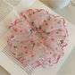Pink double layered scrunchie worn on wrist as accessory