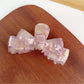 Beau hair claw clip holding dark brown hair in a half-up hairstyle