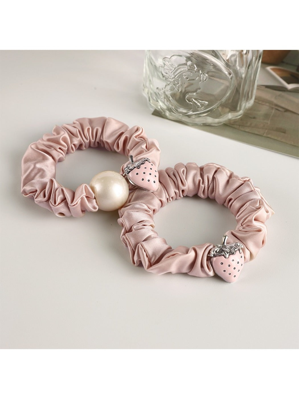 Close-up of a sweet strawberry decorated hair tie with red and green details