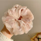 Scrunchie wrapped around a ponytail, emphasizing minimalist and cute style