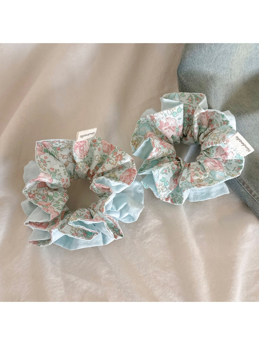 Blue ruffled scrunchie displayed on a white background