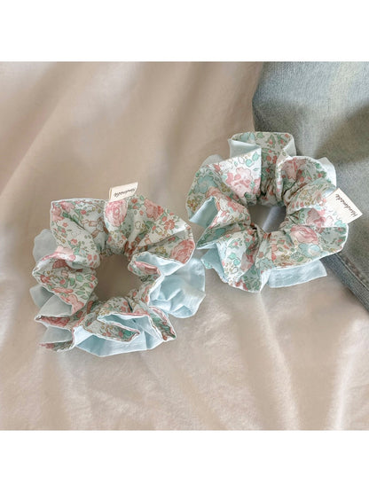 Blue ruffled scrunchie displayed on a white background