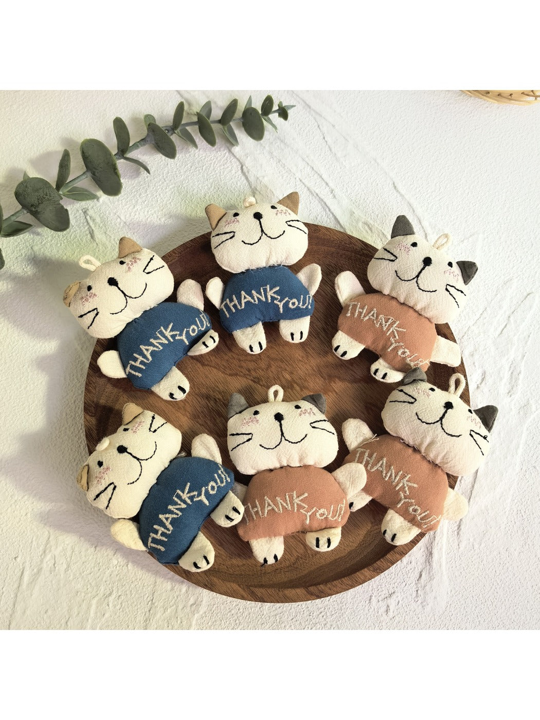 Front view of a cute cartoon cat shaped keychain with a smiling face