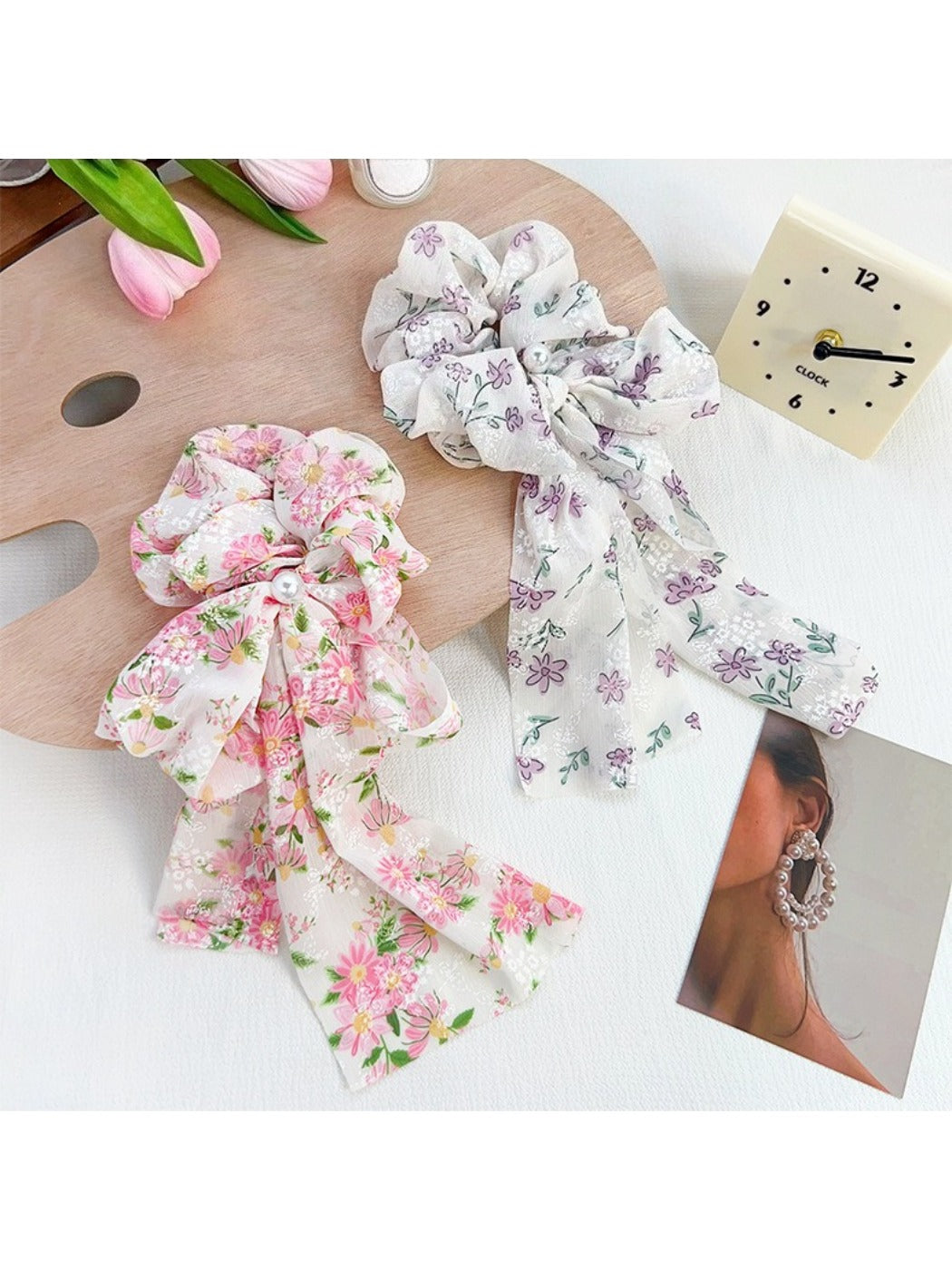 Gifty scrunchie displayed on a white background showing ruffled floral pattern and bow detail