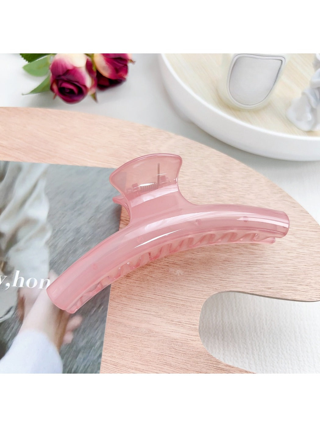 Pastel curved claw clip in lavender and cream colors on neutral backdrop