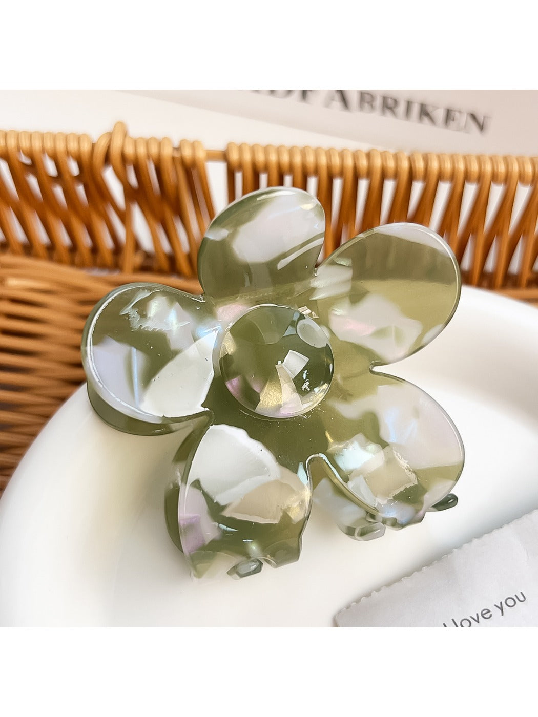 Hair claw clip shaped like a flower with bright, multicolored petals on a plain surface