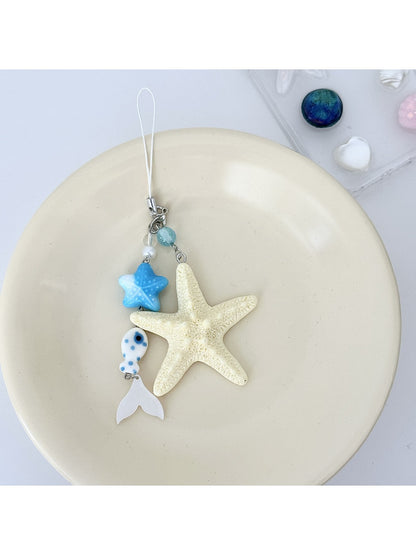 Keychain placed on a white surface highlighting starfish and fish charms