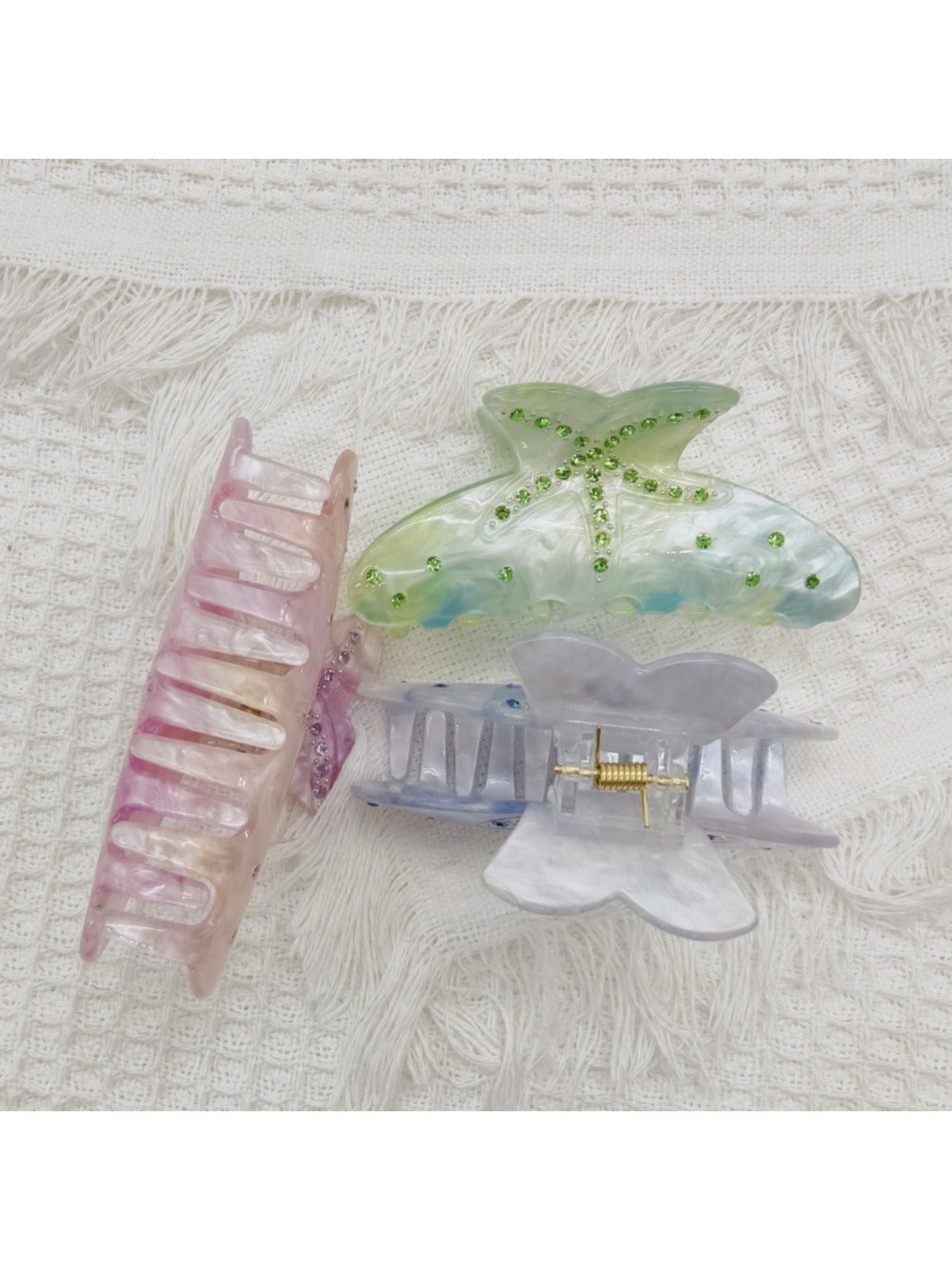Beau rainbow claw clip shown open, displaying curved teeth for secure hold