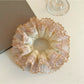 Close-up of Gifty satin hair scrunchie with delicate lace trim in soft pink