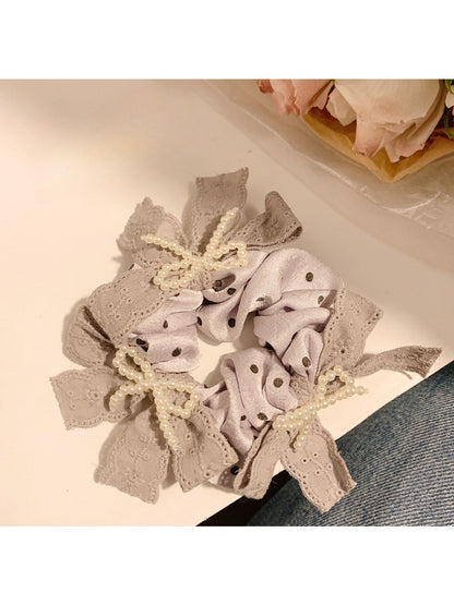 Gifty lace bow polka dot scrunchie styled in a woman's hair