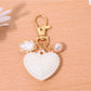 Red leather heart shaped bag charm keychain shown from top angle on flat surface
