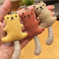 Side view of the long-tailed bear keychain highlighting its tail and plush texture
