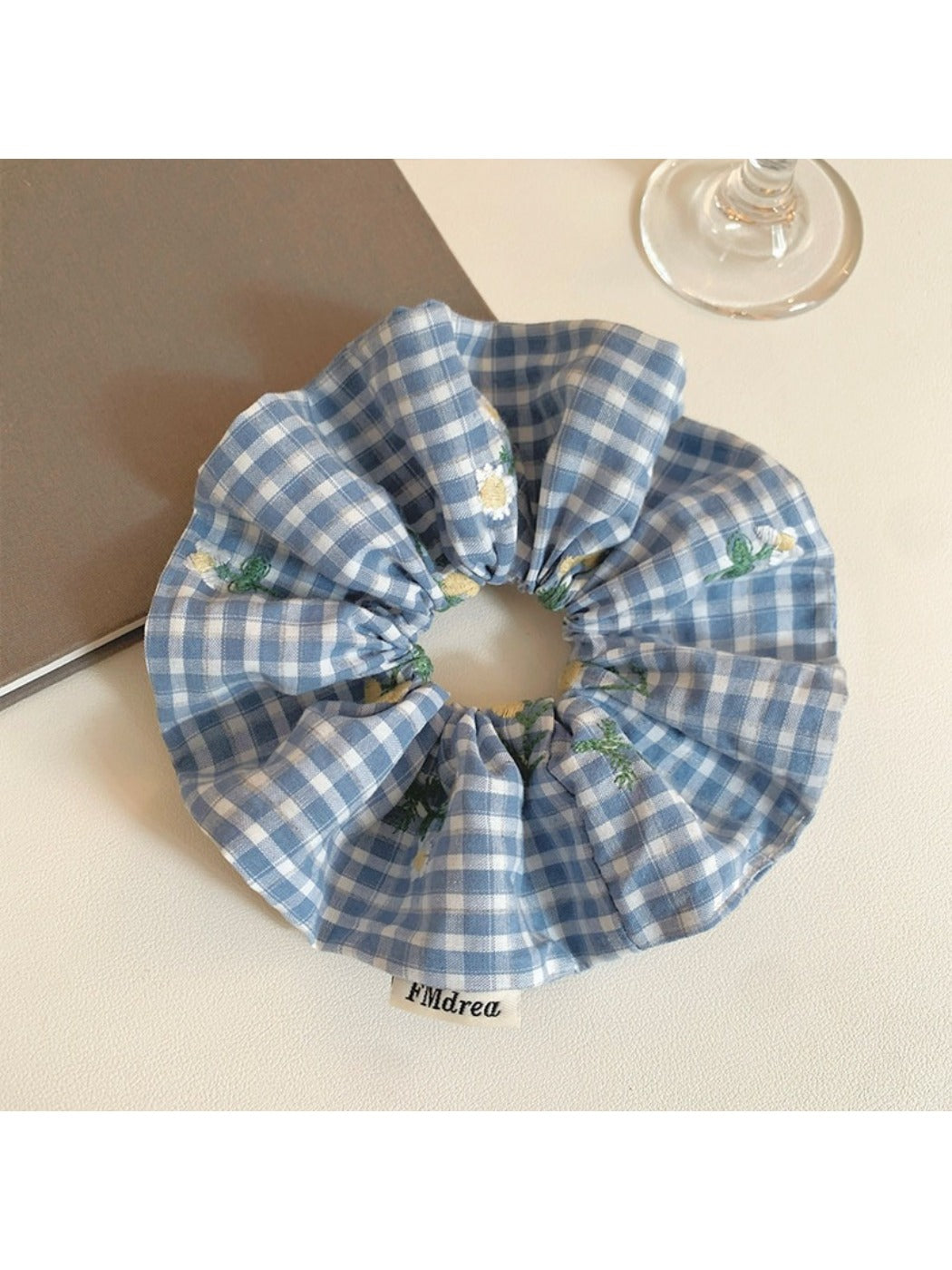 Blue plaid scrunchie with embroidered white flower detail on fabric