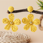 Earedge floral raffia woven vintage drop earrings next to green leaves for styling