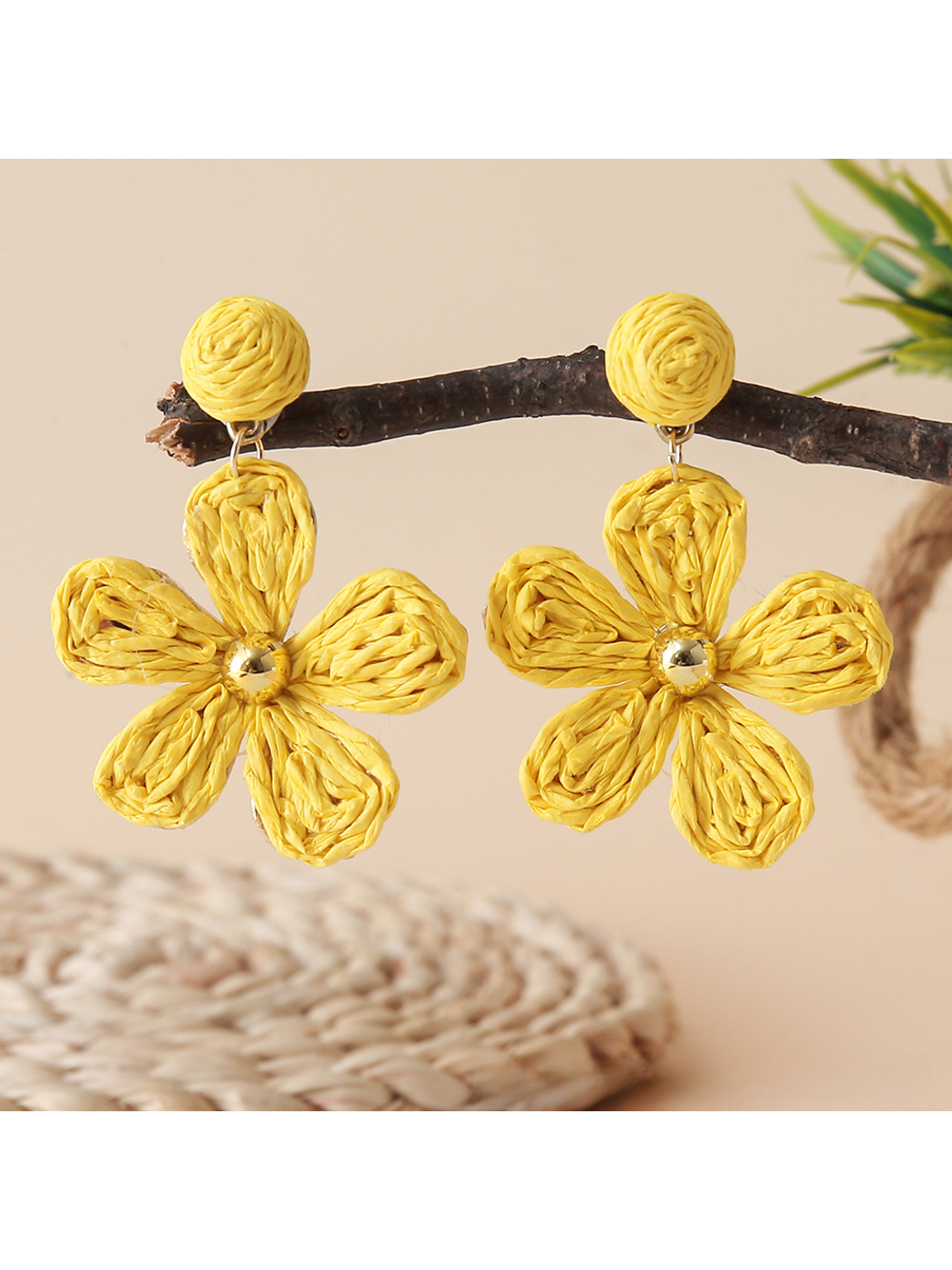 Earedge floral raffia woven vintage drop earrings next to green leaves for styling