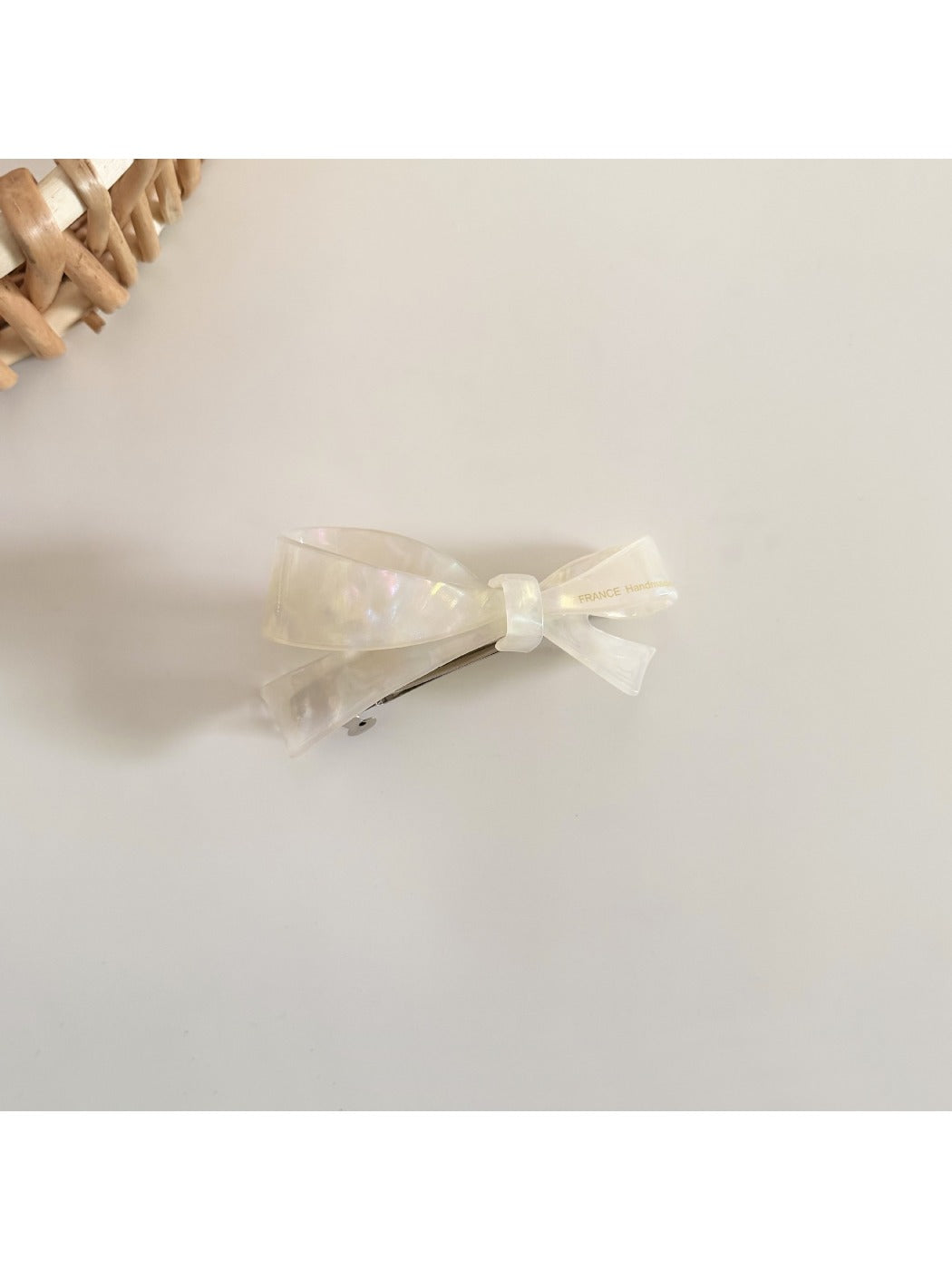Beau hair clip in soft pink on a wooden surface with natural light