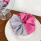 Scrunchie displayed flat highlighting magenta and pink stripes