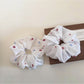 White flower scrunchie worn in hair with natural lighting