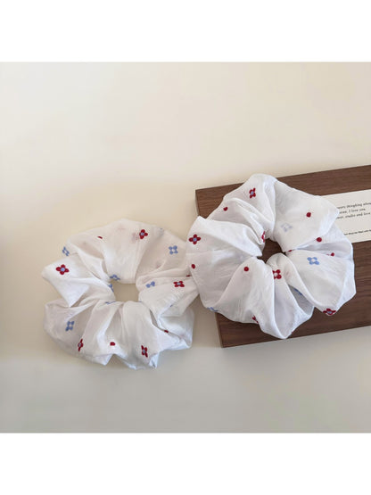White flower scrunchie worn in hair with natural lighting