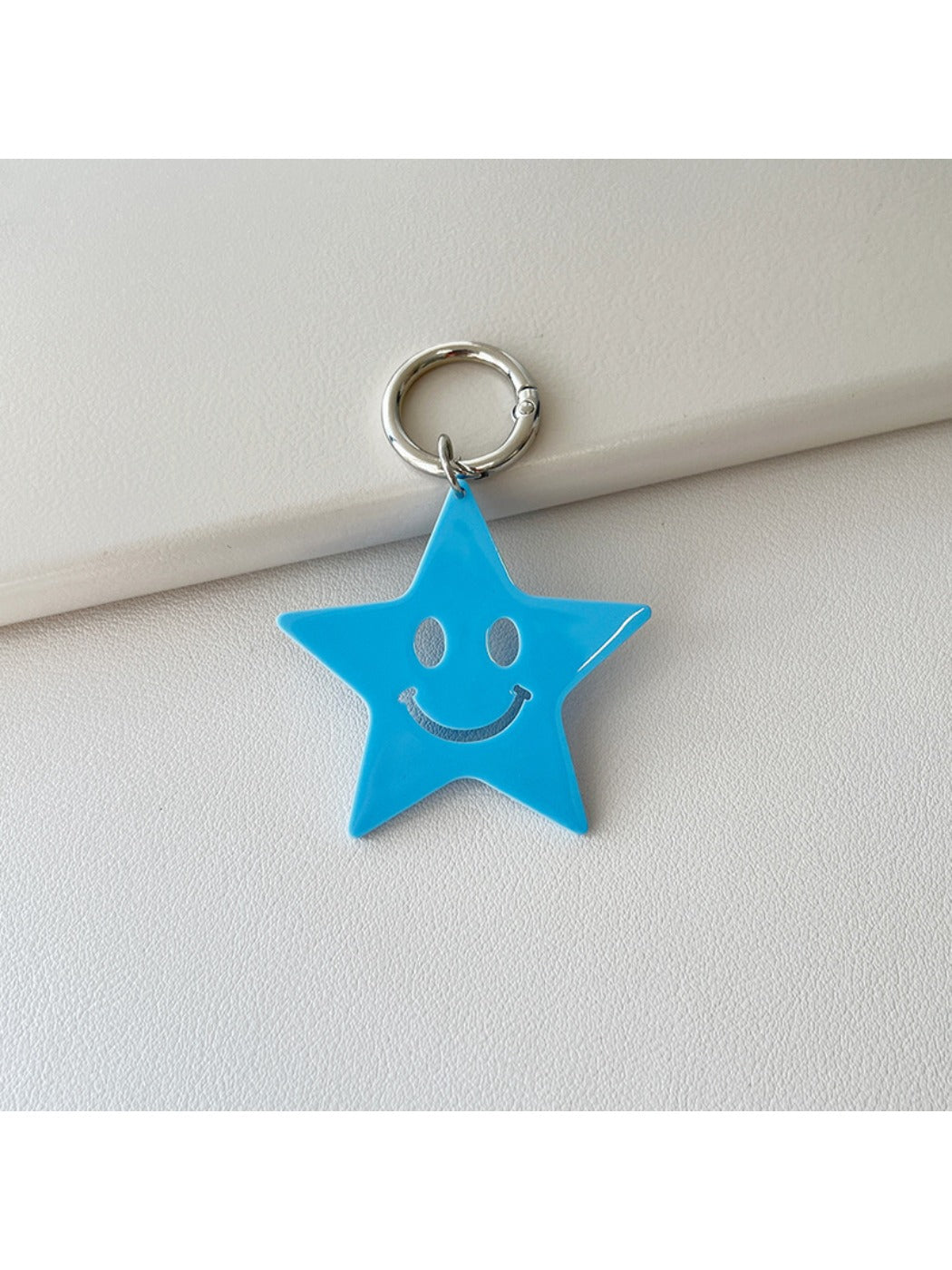 Silver star keychain placed next to a smartphone and wallet on a table