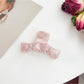 Beau bow shaped claw clip holding thick hair in an elegant updo