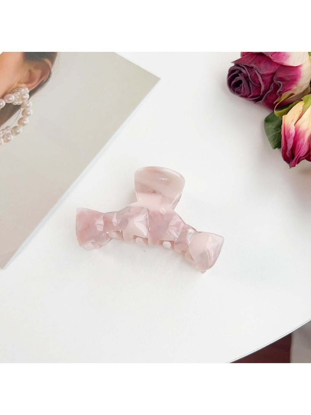 Beau bow shaped claw clip holding thick hair in an elegant updo