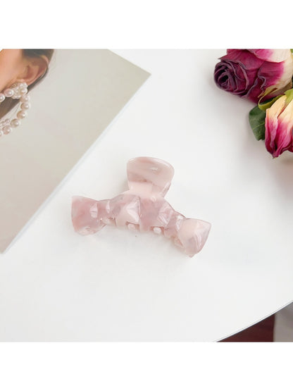 Beau bow shaped claw clip holding thick hair in an elegant updo