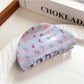Beau blue floral print shark claw clip angled to show curvature