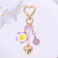 Red heart flower keychain hanging from a handbag strap