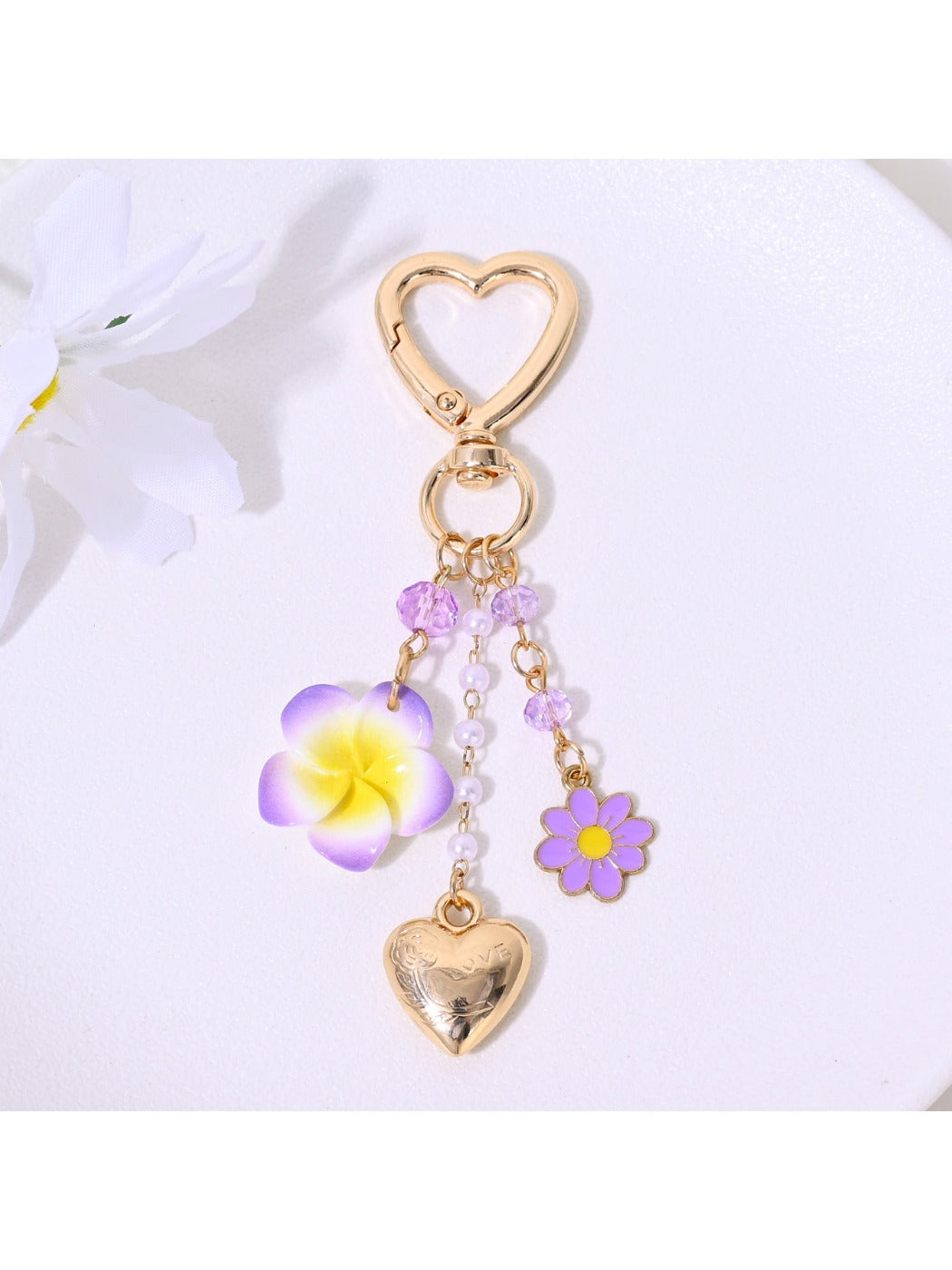 Red heart flower keychain hanging from a handbag strap