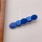 Beau hair clip with pink rose decoration placed next to flowers