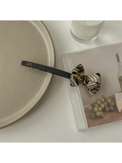 Beau minimalist bow bar hair clip shown with open clasp mechanism