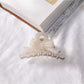Beau acetate bow shaped claw clip with light reflection on glossy surface